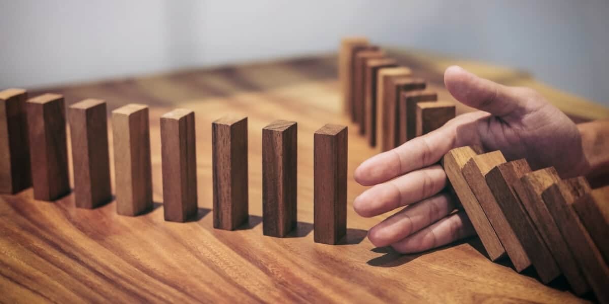 hand stopping row of blocks from falling