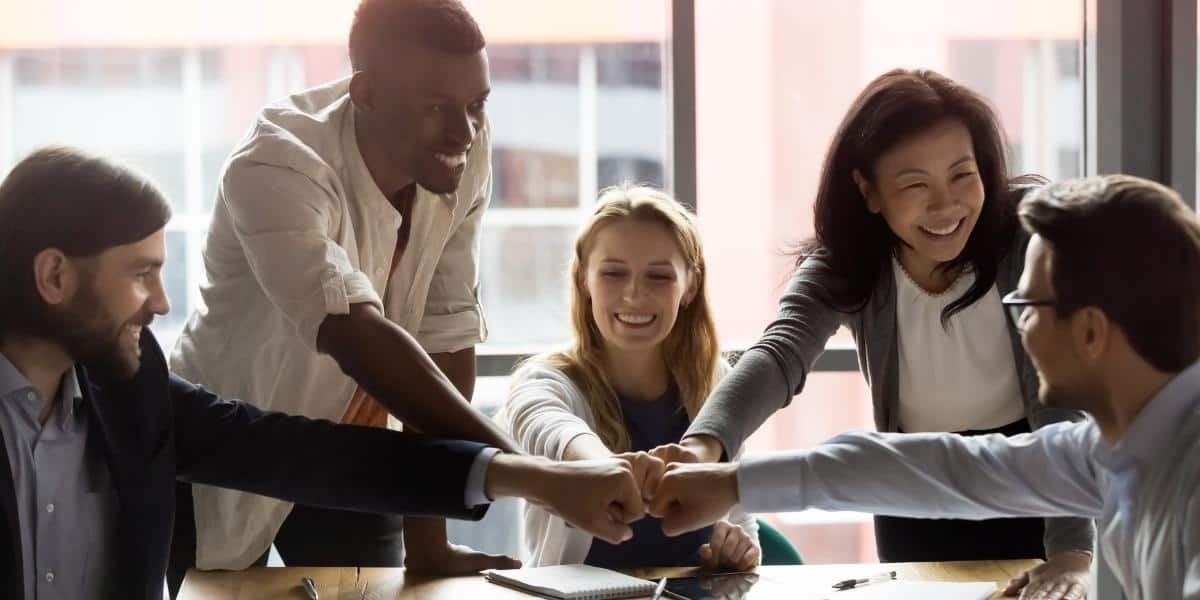 coworkers with hands together in celebration