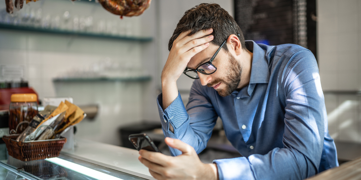 Man with hand on head suffering from imposter syndrome